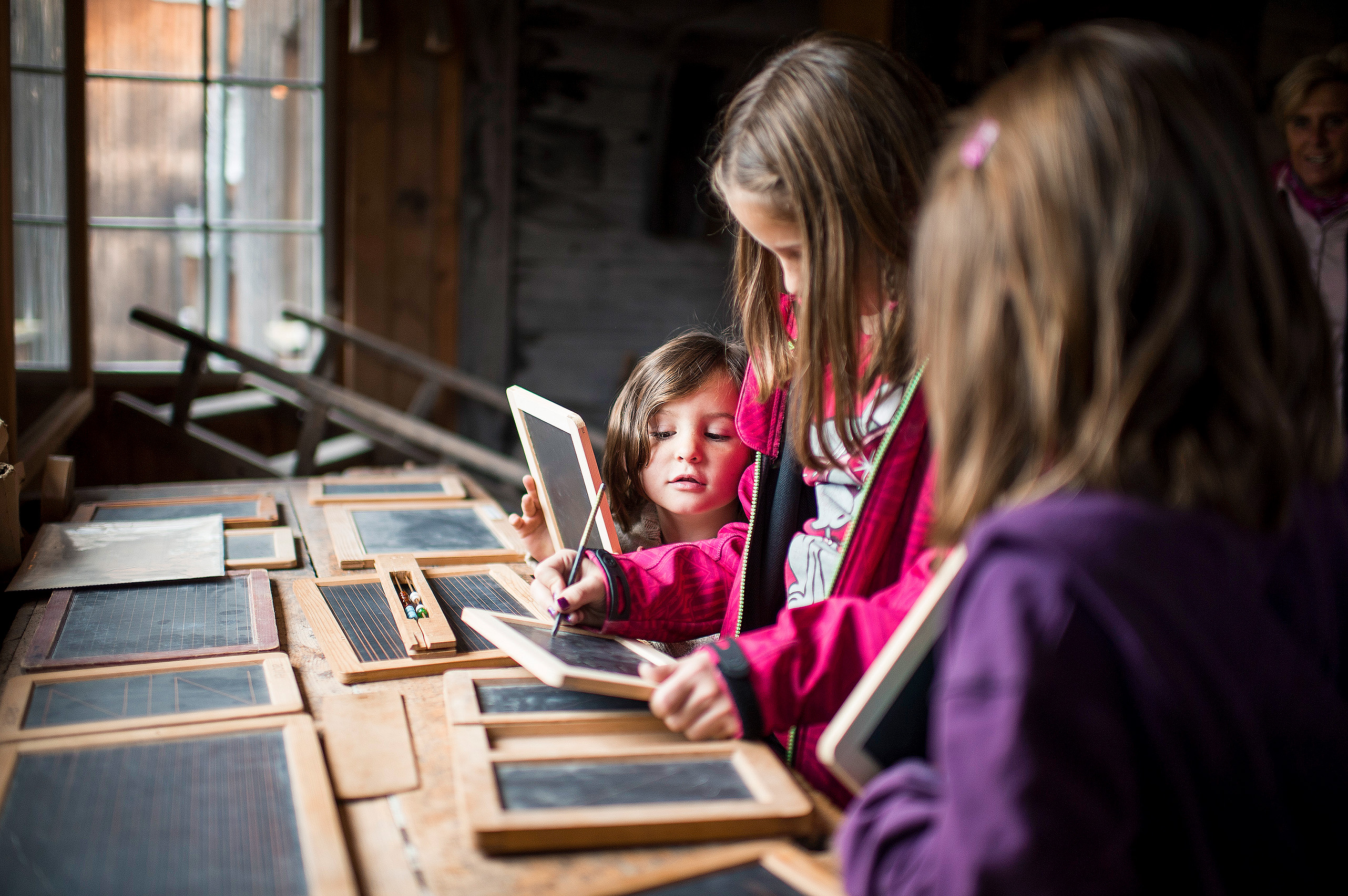 Kinder schreiben in der Schiefertafelfabrik Elm auf Schiefertafeln