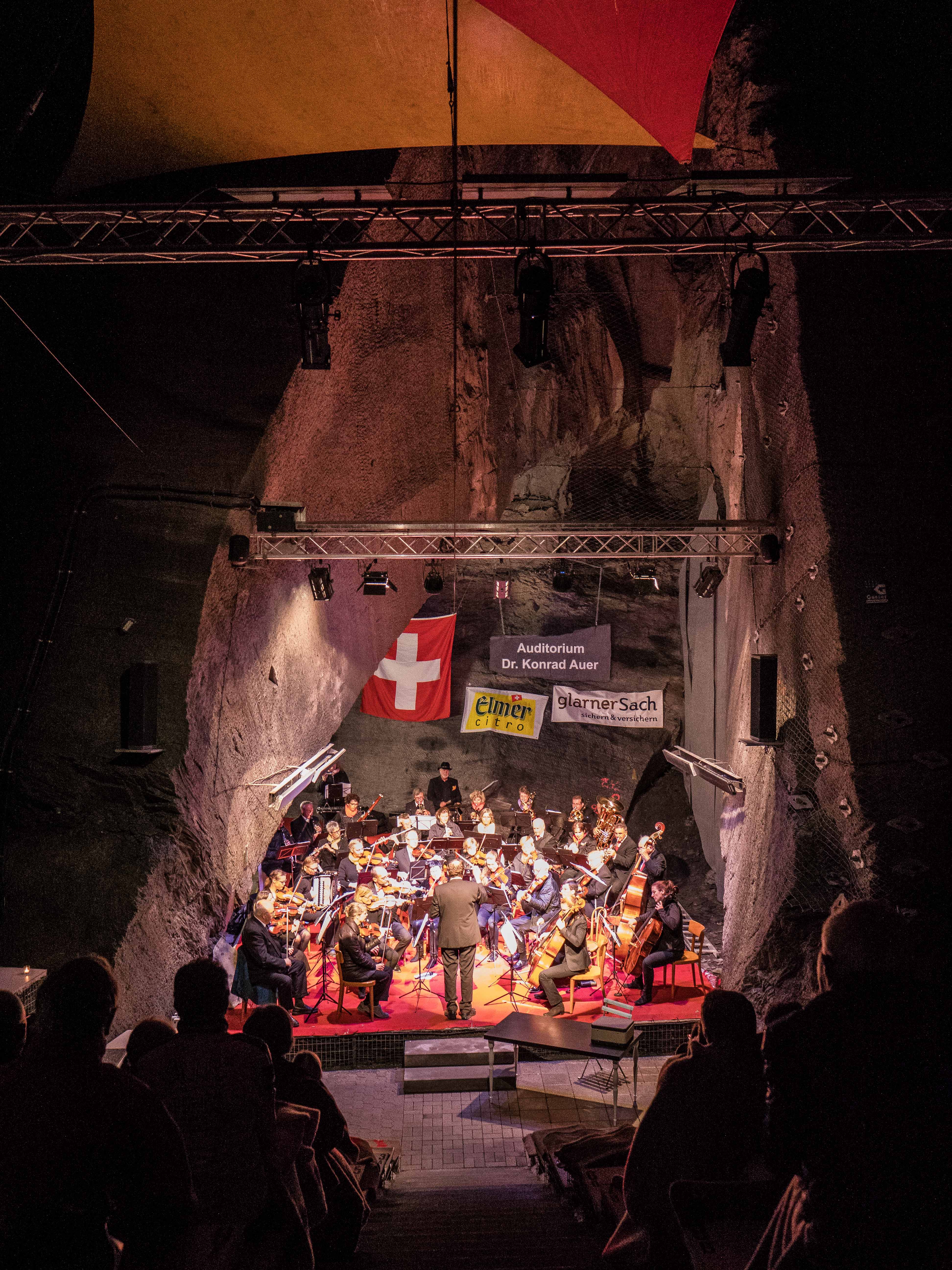 Blick in das hohe Felsauditorium mit Bühne und Orchester