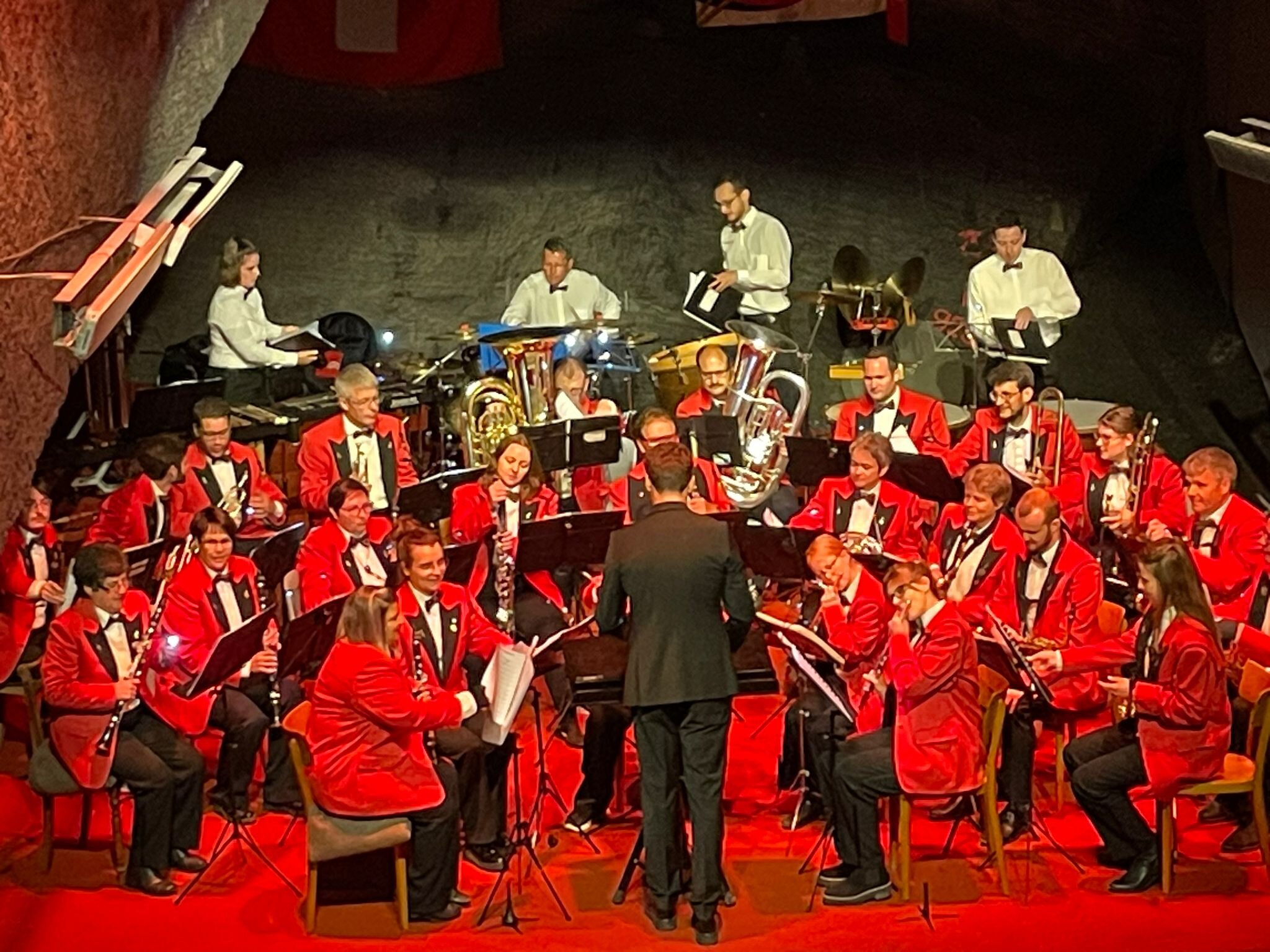 Harmoniemusik und Dirigent im rot beleuchteten Auditorium des Landesplattenbergs